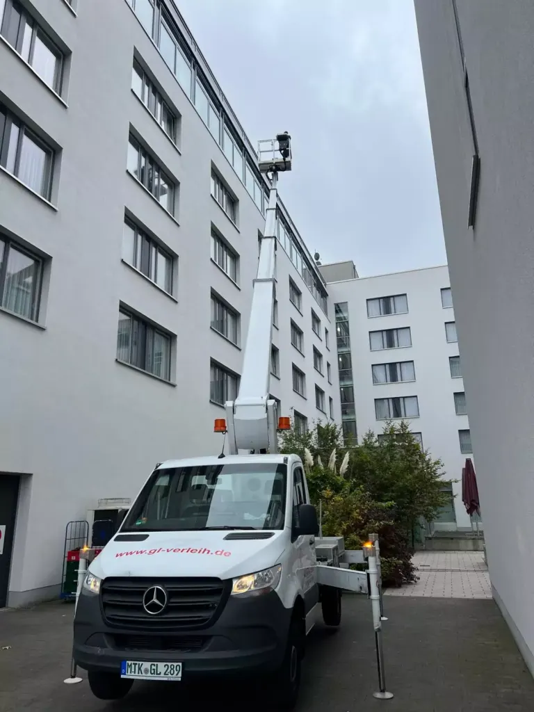 Ausgefahrene Hubarbeitsbühne im Innenhof zwischen hohen Gebäuden