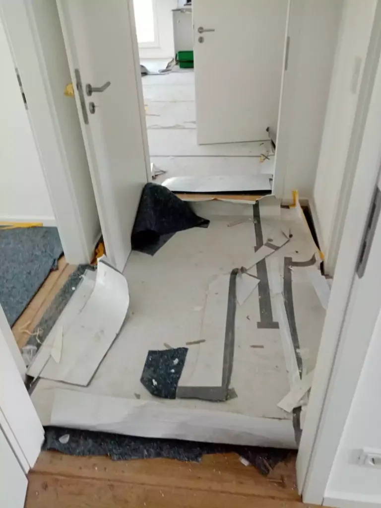 Flur mit Abdeckvlies und Bauresten vor der Endreinigung