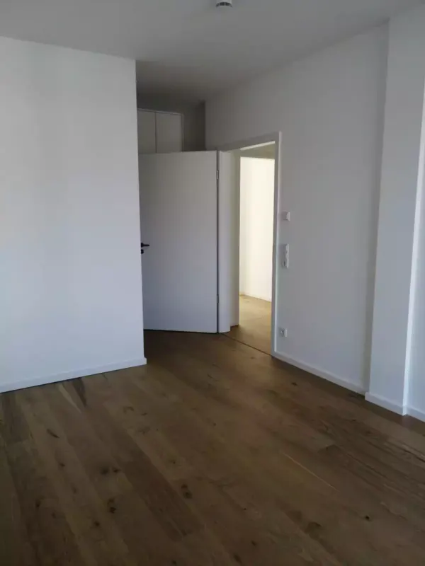 Frisch gereinigtes leeres Zimmer mit Parkettboden im Neubau