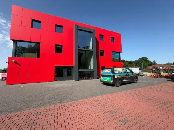 Dreigeschossiges Bürogebäude mit roter Plattenfassade nach der Fassadenreinigung