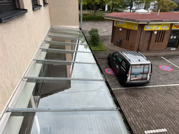 Frisch gereinigtes Glasvordach eines Gewerbegebäudes von oben